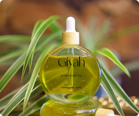 Giyah rosemary oil dropper bottle with green leaves in the background