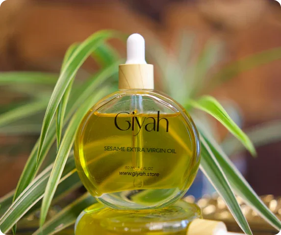 Giyah sesame extra virgin oil bottle with dropper, green plant in background